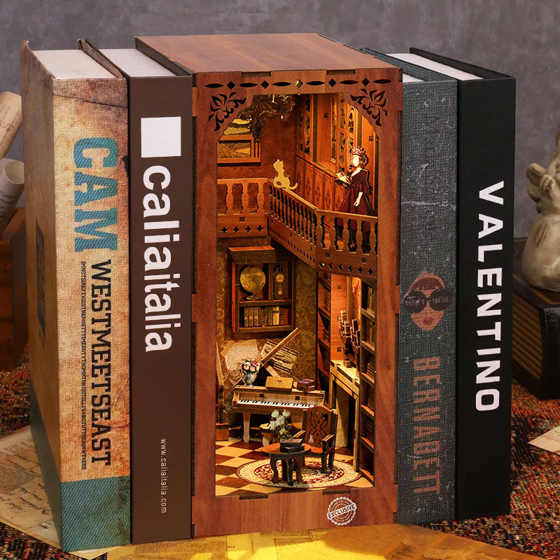 Kit DIY Book Nook Grimm’s Small Building : une maquette de bibliothèque miniature en bois avec éclairage LED, insérée entre des livres sur une étagère.