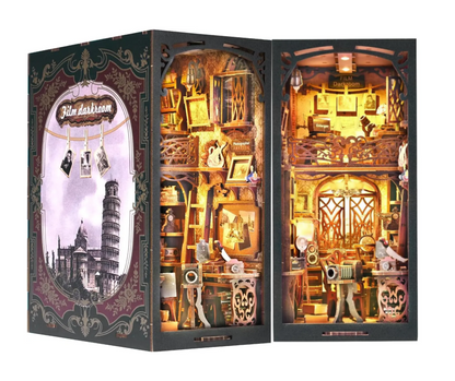 Vue d'ensemble de la maquette 'Film Darkroom' (chambre noire) montrant le décor extérieur illustré de la Tour de Pise et l'intérieur détaillé d'un studio photo vintage avec éclairage LED.