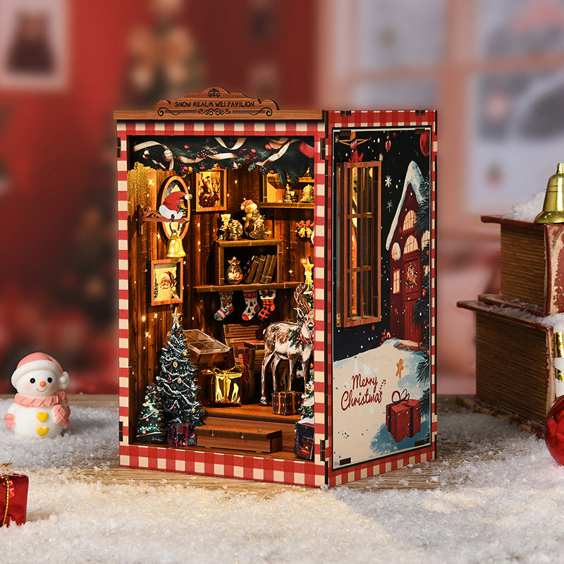 Kit DIY Book Nook de Noël 'Snow Realm Pavilion' : serre-livres miniature avec sapin, renne, cadeaux et éclairage LED chaleureux dans une ambiance hivernale.