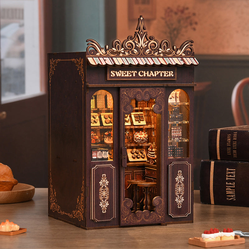 Kit DIY Book Nook 'Sweet Chapter' : maquette de pâtisserie miniature en bois avec éclairage LED. Serre-livres décoratif représentant une boutique de chocolats et gâteaux artisanaux avec porte ouverte.