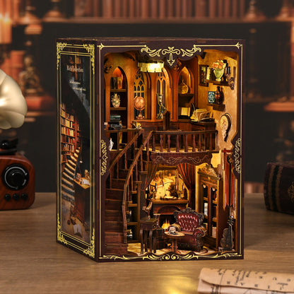 Miniature en bois d'une bibliothèque classique à deux étages insérée dans un coffret, présentant un escalier courbe, des étagères remplies de livres miniatures et un fauteuil près d'une cheminée, le tout illuminé par une lumière tamisée