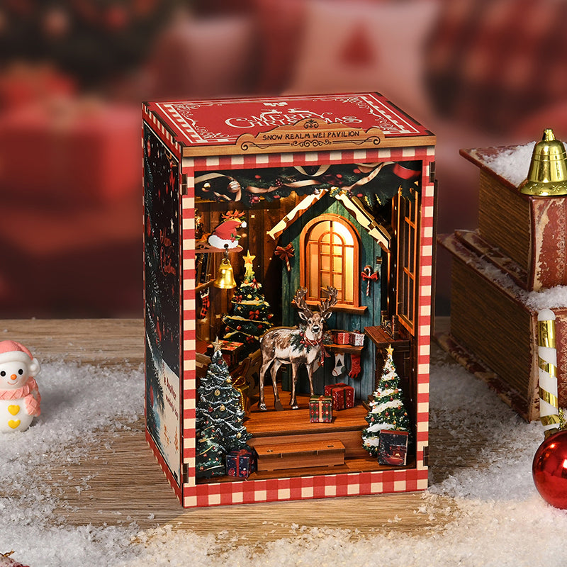 Kit DIY Book Nook de Noël 'Snow Realm Pavilion' : serre-livres miniature avec sapin, renne, cadeaux et éclairage LED chaleureux dans une ambiance hivernale.