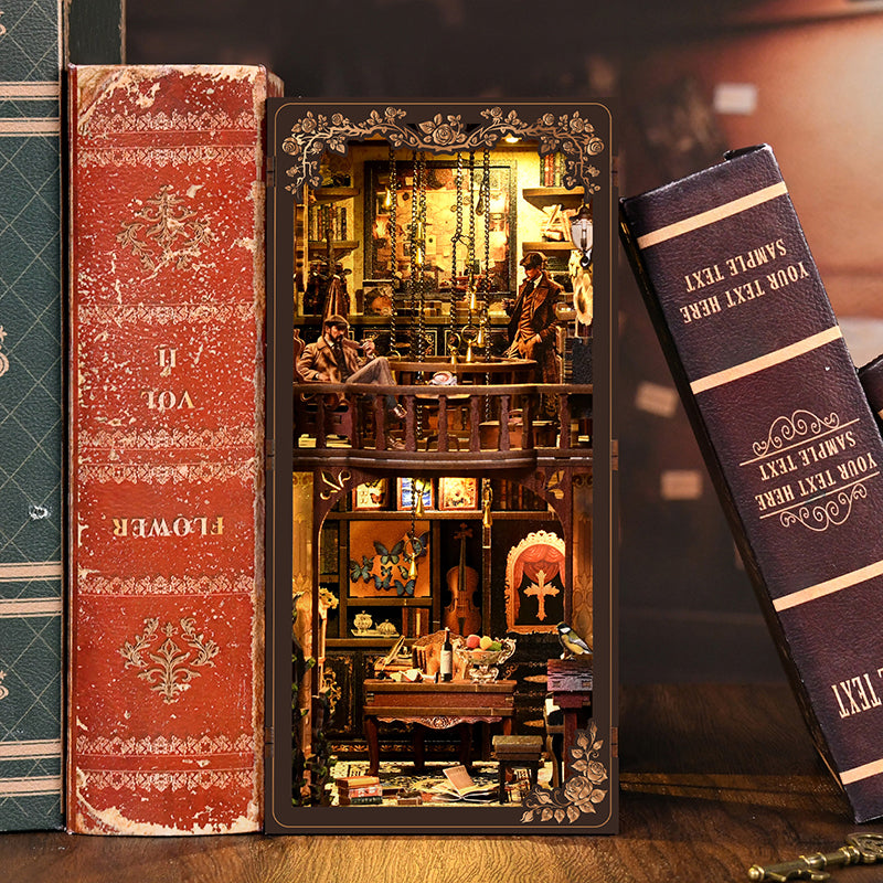 Serre-livres Book Nook miniature en bois thème détective Sherlock Holmes avec éclairage LED chaleureux, inséré entre des livres anciens.