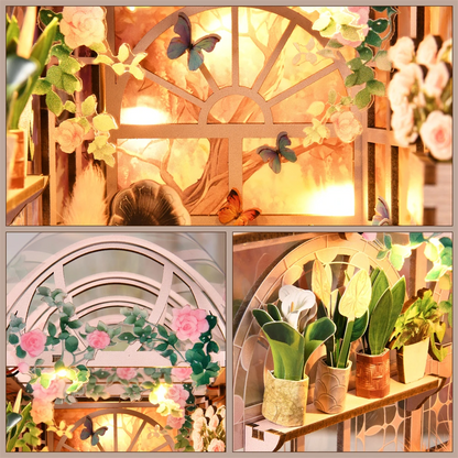 Gros plan sur une maquette de maison miniature en bois avec des fleurs roses, des papillons colorés et un éclairage LED chaleureux à travers une fenêtre en arche.