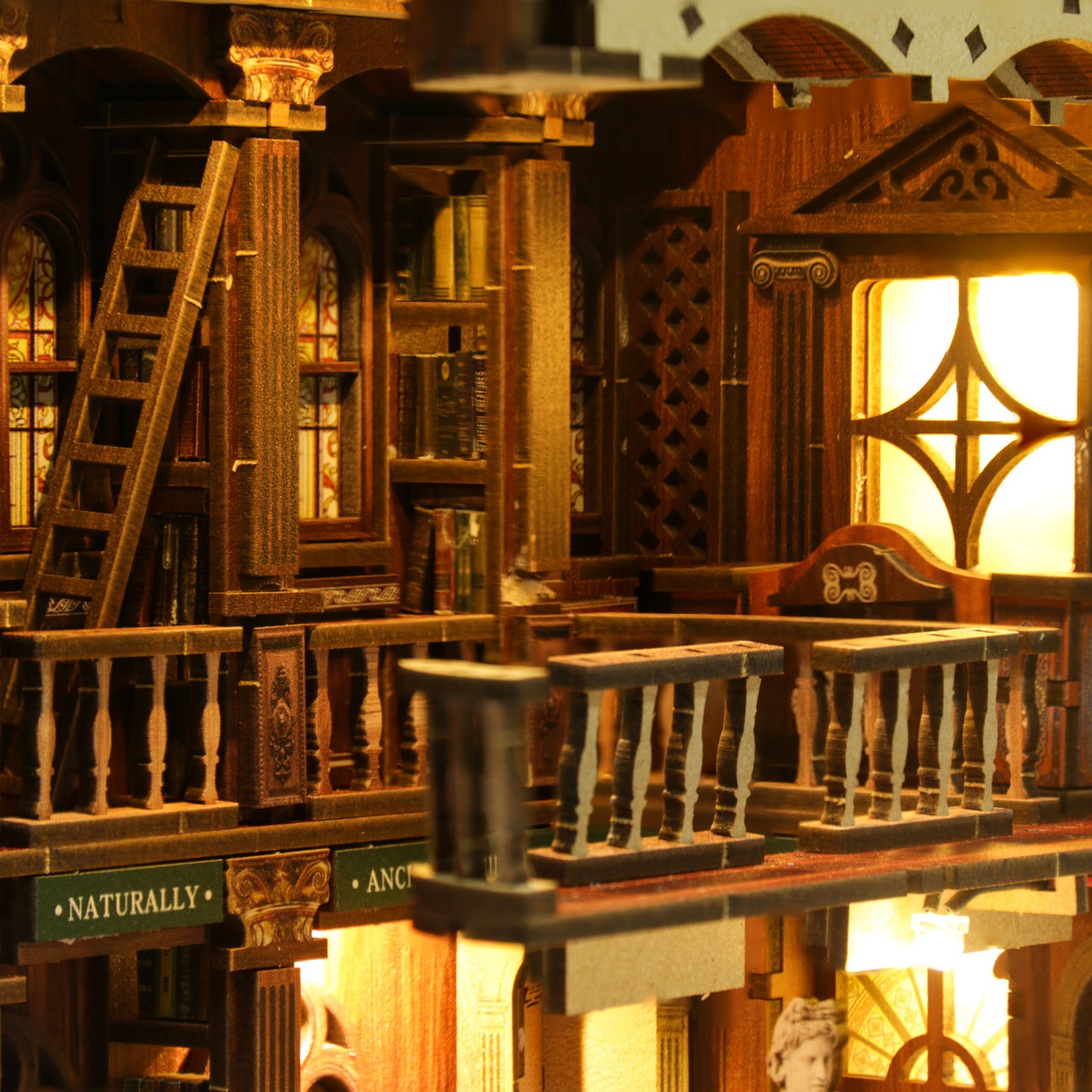 Insert de bibliothèque décoratif "The Philosophical Library" placé entre des livres anciens, créant une scène de bibliothèque classique miniature avec lumière LED chaleureuse.