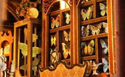 Gros plan d'une vitrine de collectionneur miniature style vintage avec des spécimens de papillons colorés exposés dans des casiers en bois doré et sculpté.