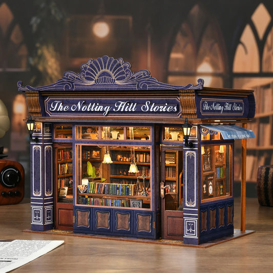 "Book nook" miniature représentant une librairie ancienne intitulée "The Notting Hill Stories". Le diorama illuminé montre une vitrine détaillée remplie de livres et d'objets de décoration dans une ambiance feutrée et chaleureuse.