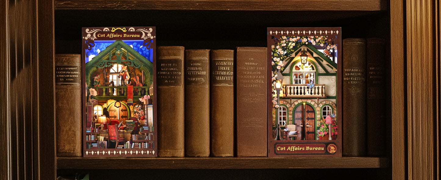 Deux serre-livres décoratifs Book Nook "Cat Affairs Bureau" installés sur une étagère en bois entre des livres anciens, avec éclairage LED nocturne chaleureux.