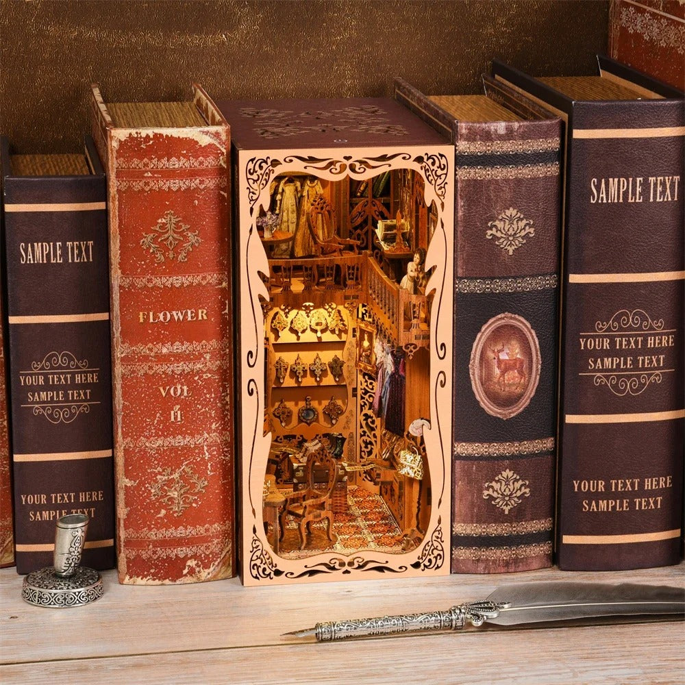 Maquette serre-livres DIY (Book Nook) installée dans une bibliothèque, représentant une boutique de mode rétro ou un dressing luxueux avec des robes miniatures, des sacs à main, un escalier élégant et des étagères de bijoux dorés.