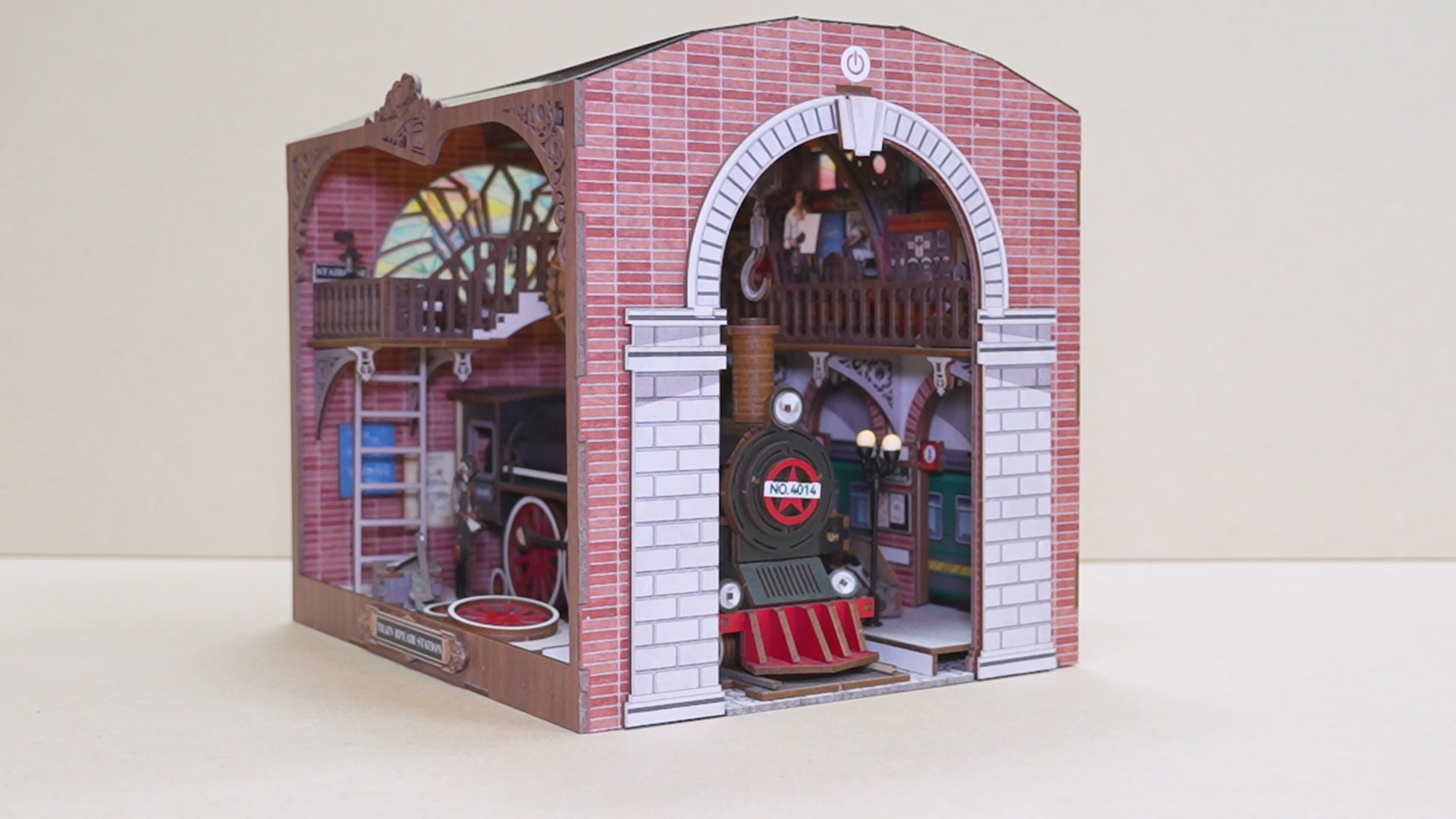 Gros plan sur les détails d'un book nook Cathédrale : figurine de Jésus-Christ, vitraux d'anges miniatures, allée centrale avec bancs et décoration florale.