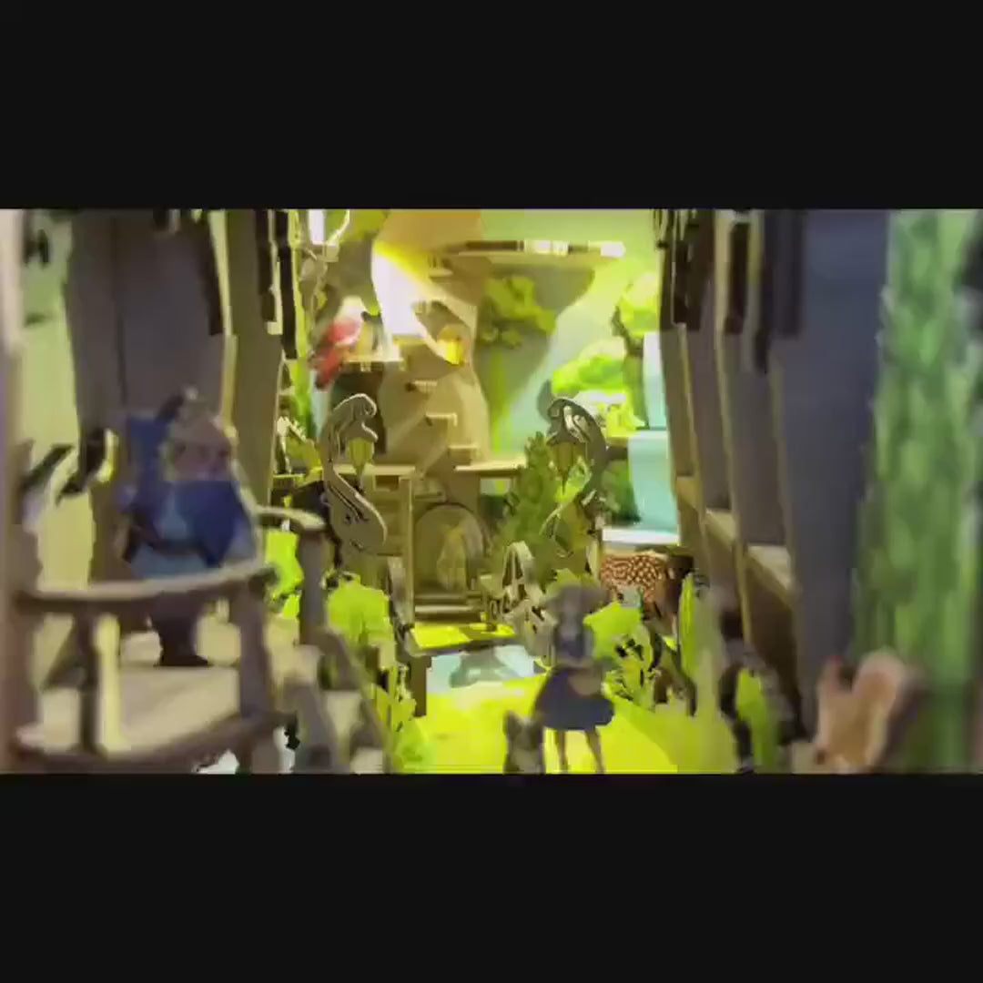 Vidéo de présentation du Book Nook Magicien d'Oz montrant le montage étape par étape des pièces en bois et le résultat final illuminé avec Dorothy sur le chemin de briques jaunes.