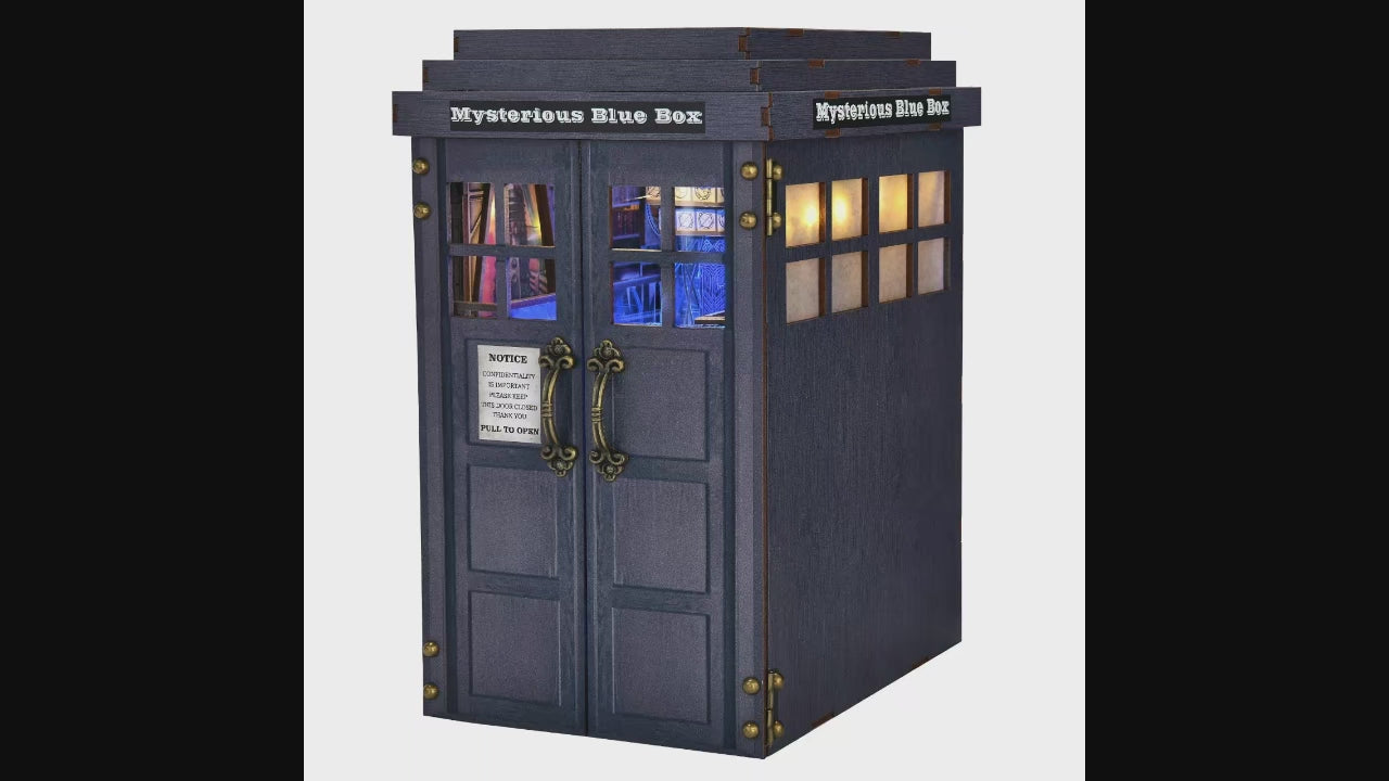 Kit Book Nook DIY "Mysterious Blue Box" en bois, inspiré d'une cabine de police bleue. L'intérieur détaillé s'éclaire d'un bleu intense via un interrupteur tactile, révélant une salle de contrôle futuriste avec des figurines, une console centrale et des bibliothèques miniatures. Dimensions : 18 x 13 x 24 cm.