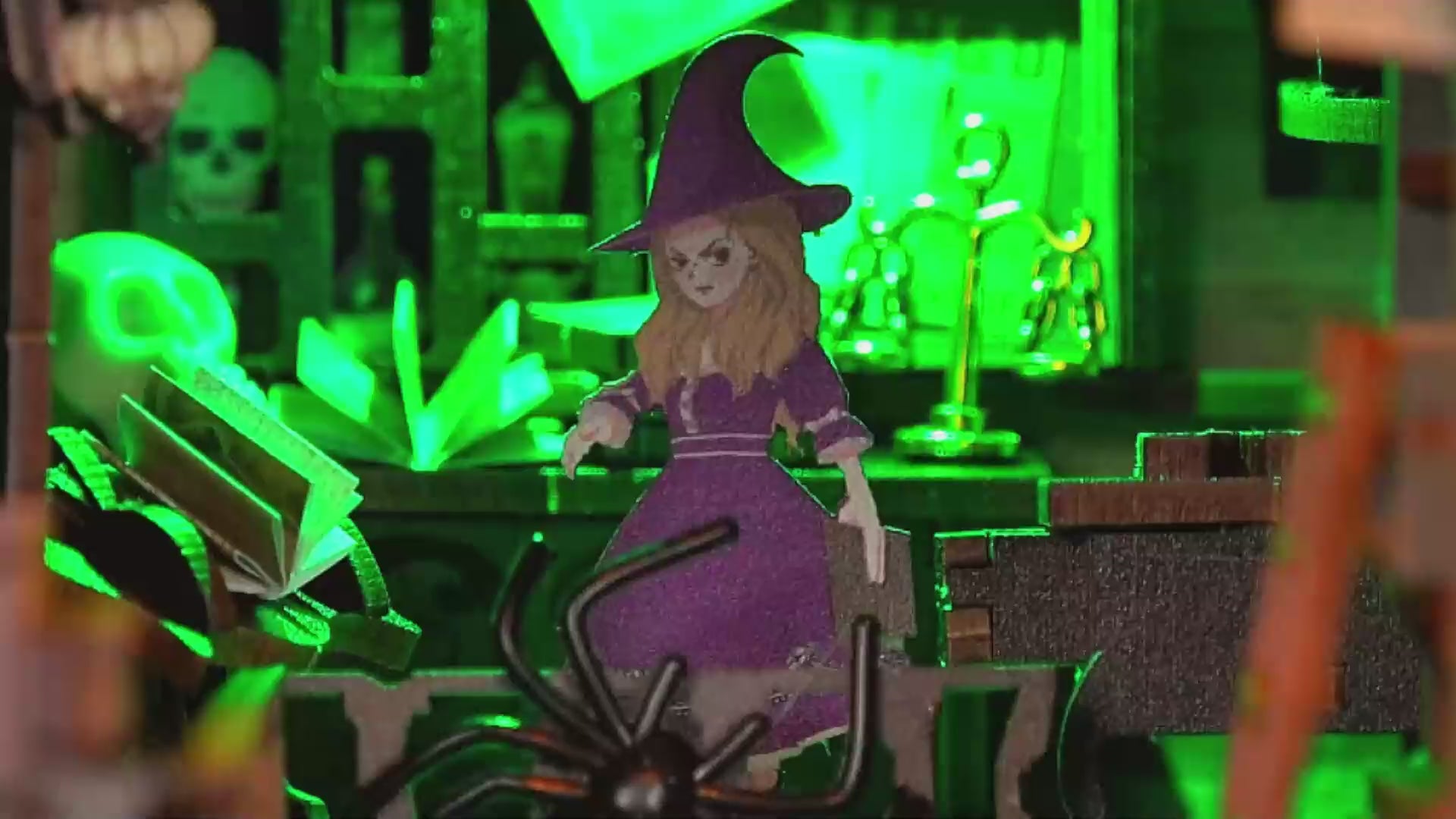 Vidéo de présentation du kit DIY Book Nook 'The Master's House'. On y voit les étapes d'assemblage des meubles miniatures, l'installation des figurines de sorcière et de chat noir, ainsi que le rendu final illuminé par des LED vertes et chaleureuses au milieu d'une bibliothèque