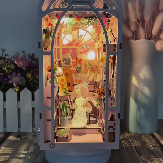 Vidéo de présentation de la serre miniature 'Mini Greenhouse' pivotante à 360°, montrant les détails intérieurs : gramophone miniature, chevalet de peintre, plantes en pot et jeux de lumières LED.