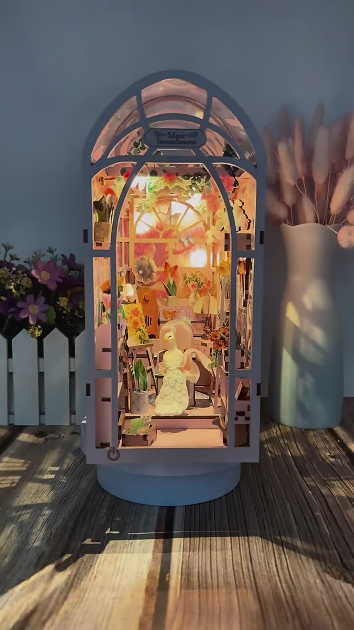 Vidéo de présentation de la serre miniature 'Mini Greenhouse' pivotante à 360°, montrant les détails intérieurs : gramophone miniature, chevalet de peintre, plantes en pot et jeux de lumières LED.