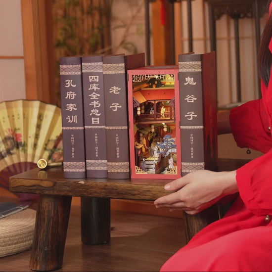 Assemblage d'un kit Book Nook DIY en bois sur le thème de la Chine ancienne, montage de maquette miniature avec personnages et décors traditionnels.