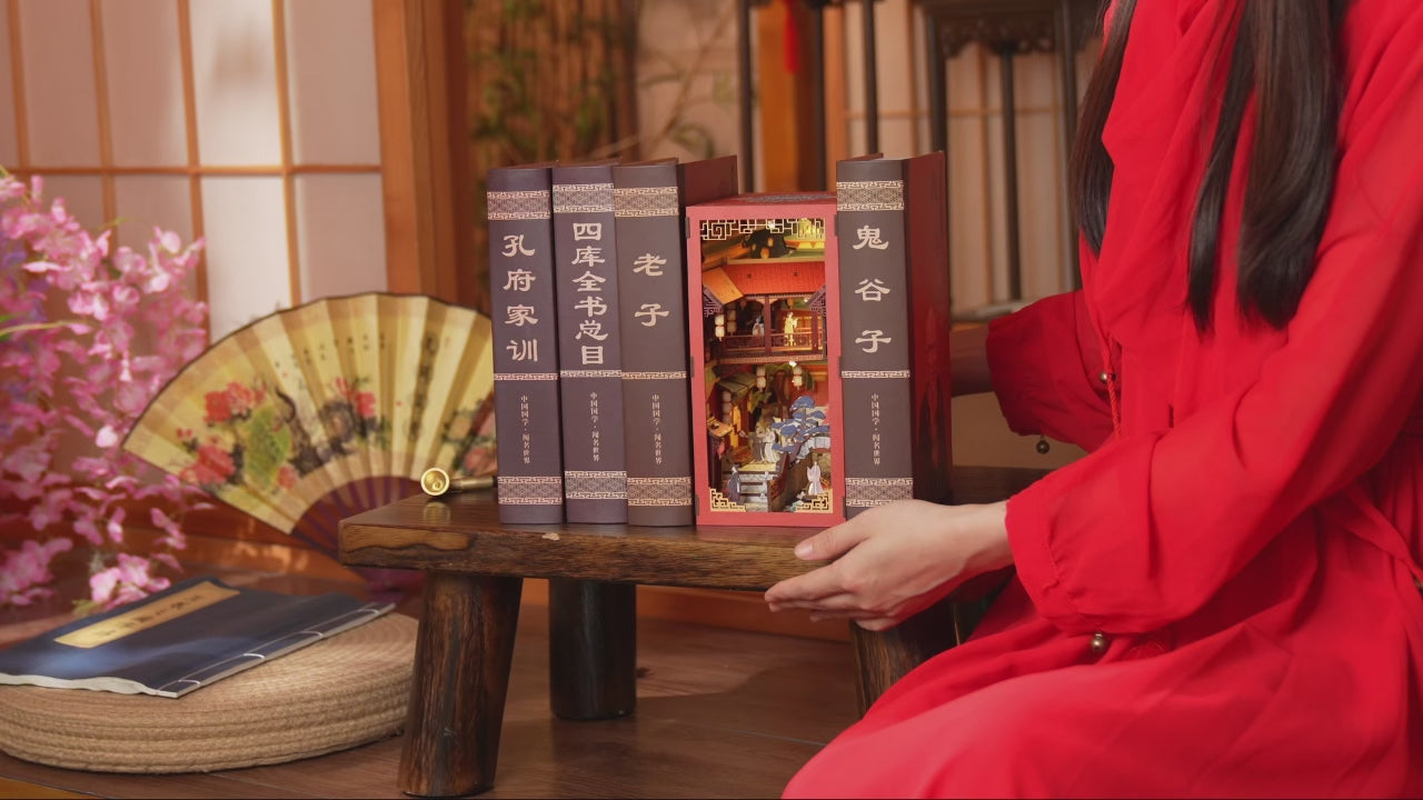 Assemblage d'un kit Book Nook DIY en bois sur le thème de la Chine ancienne, montage de maquette miniature avec personnages et décors traditionnels.